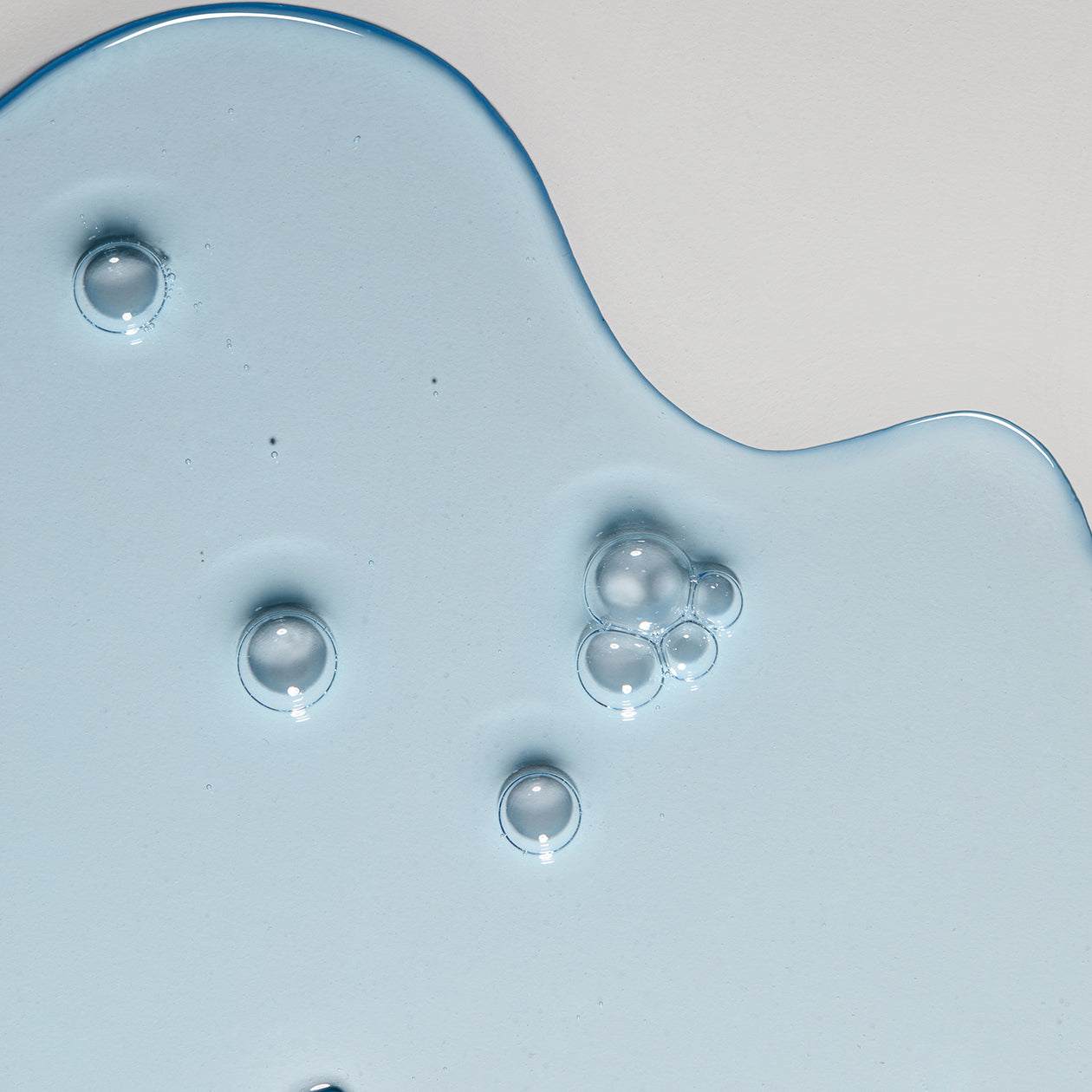 Close-up texture of Obagi ELASTIderm Eye Serum lightweight fluid, fast-absorbing formula for smoothing, hydrating, and tightening delicate under-eye skin.