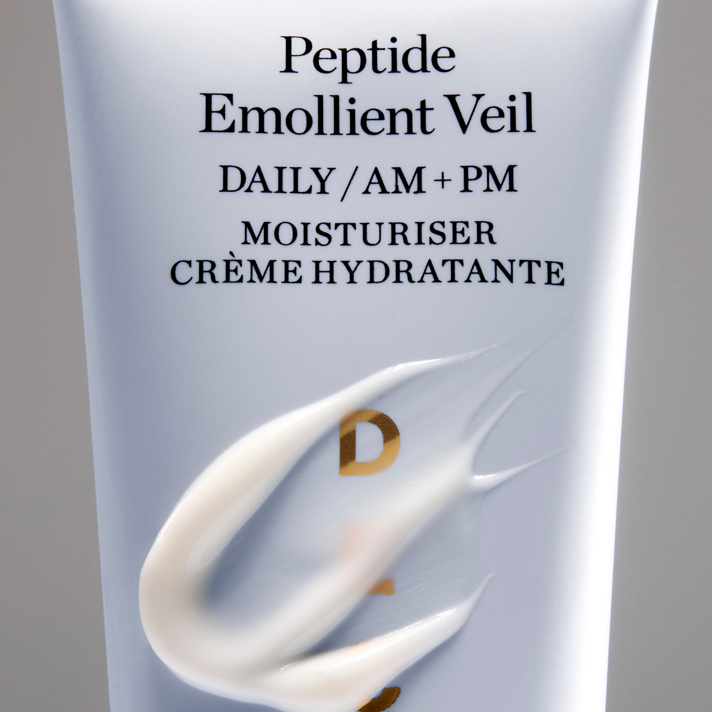 Moisturizer tube labeled 'Peptide Emollient Veil' with a gray background
