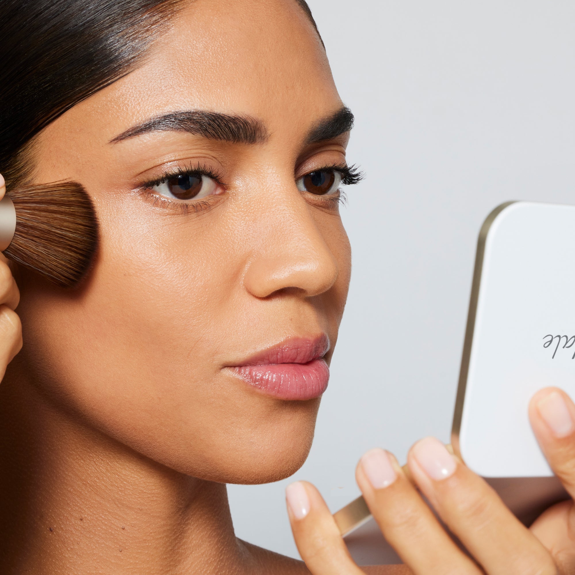 PurePressed Base being applied with brush—lightweight, buildable foundation with sun protection.