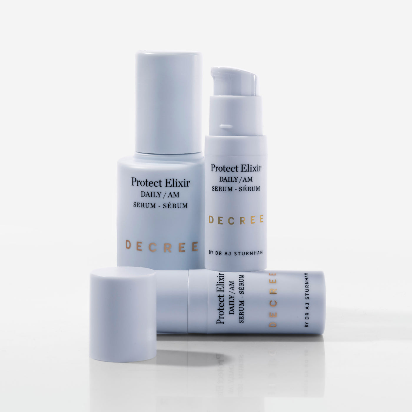 Decree Protect Elixir 30 ml facial serum packaging for brighter, firmer, more resilient-looking skin. Three bottles of Decree Protect Elixir serum on a white background.