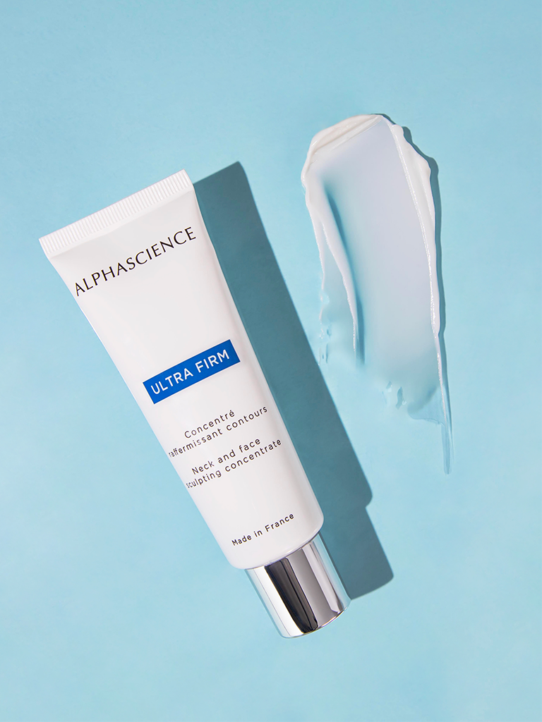 Alphascience Ultra Firm skincare concentrate tube + texture on a light blue background.