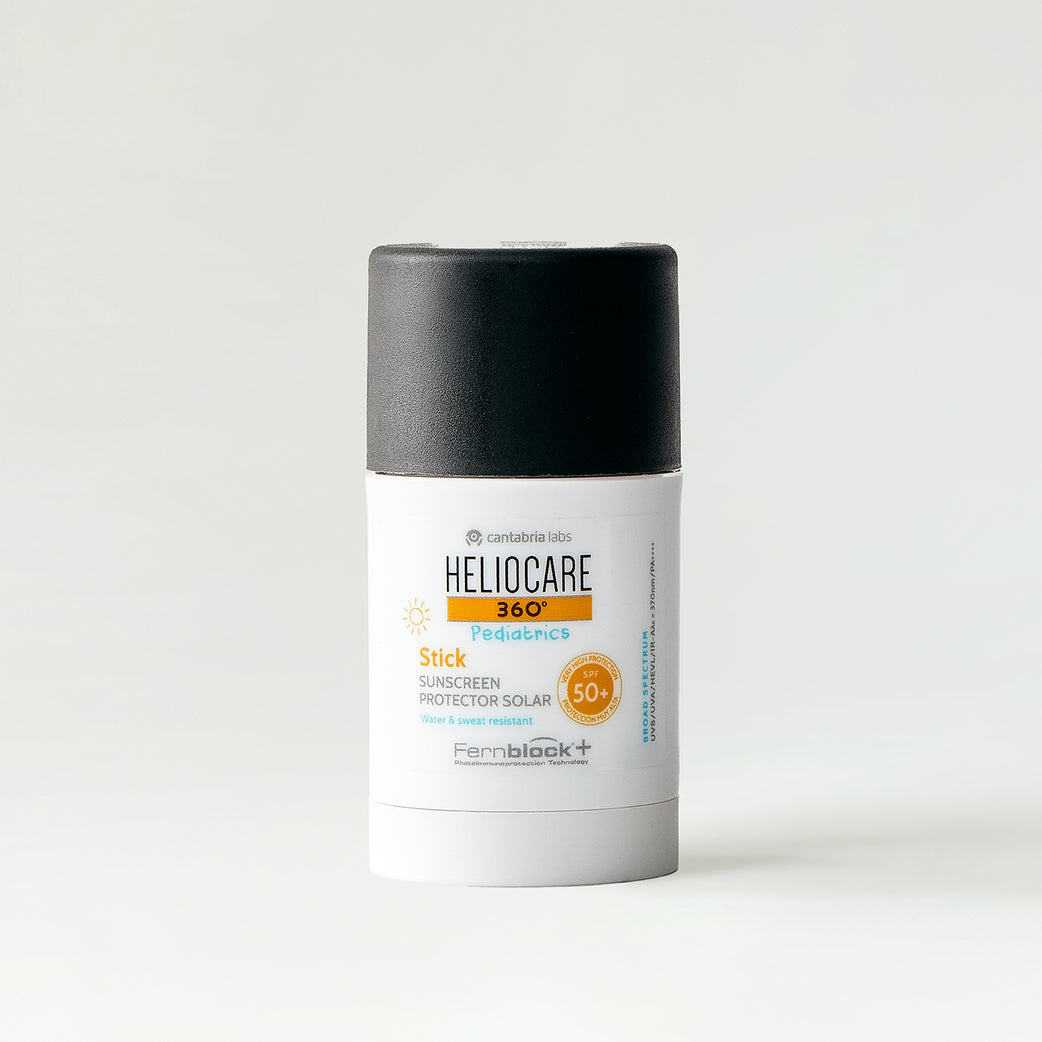 A single stick sunscreen bottle from Heliocare, featuring a white body with a black cap, set against a clean white background. Heliocare 360º Pediatrics Stick SPF50+ white and orange sun stick for children on white background