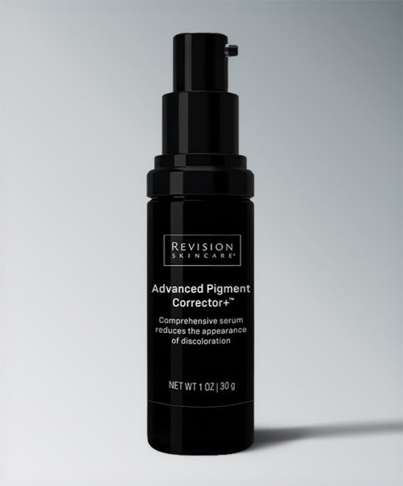 A black pump bottle of Revision Skincare Advanced Pigment Corrector+ serum, shown against a neutral gray gradient background. Revision Advanced Pigment Corrector+™ hydroquinone-free serum for dark spots, discoloration, and uneven skin tone.