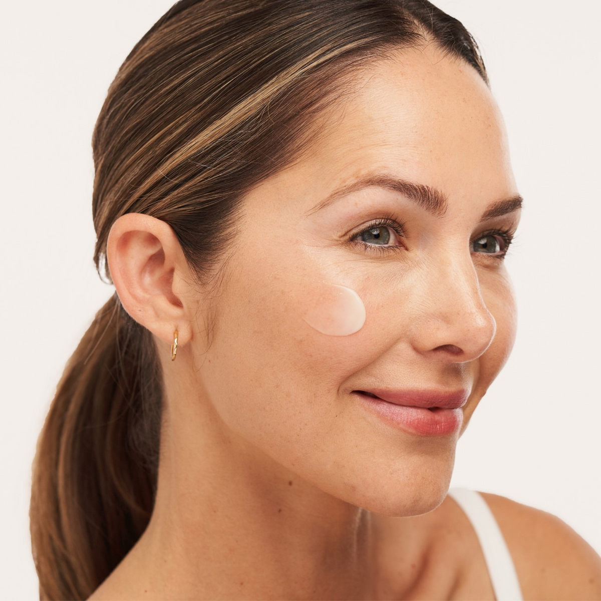 Model applying Alastin C-RADICAL Defense Antioxidant Serum to freshly cleansed skin as part of a morning routine.