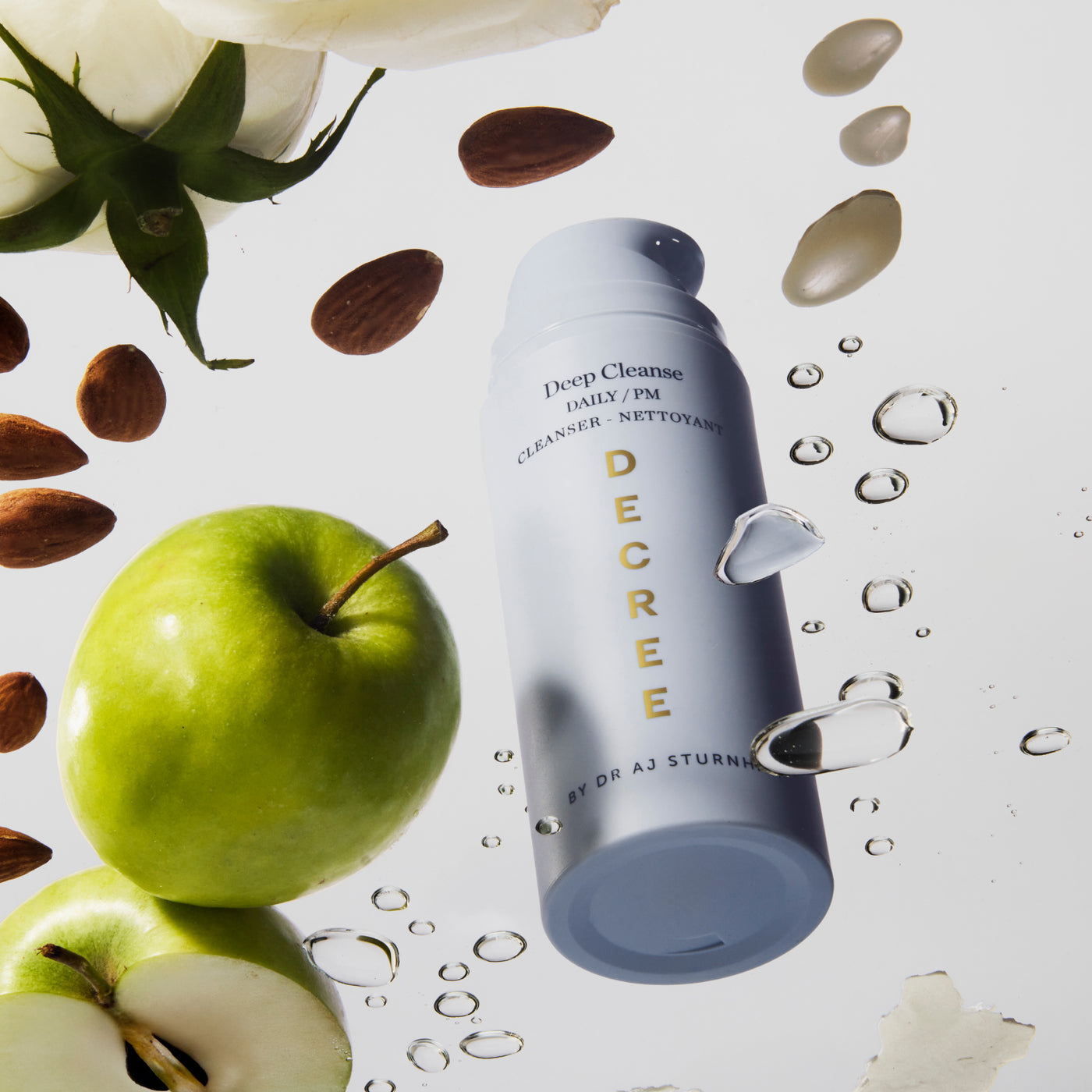 Decree Deep Cleanse Skincare product with apples and almonds on a light background. Decree Deep Cleanse cleanser for decongested pores, refined texture, and a brighter-looking complexion.