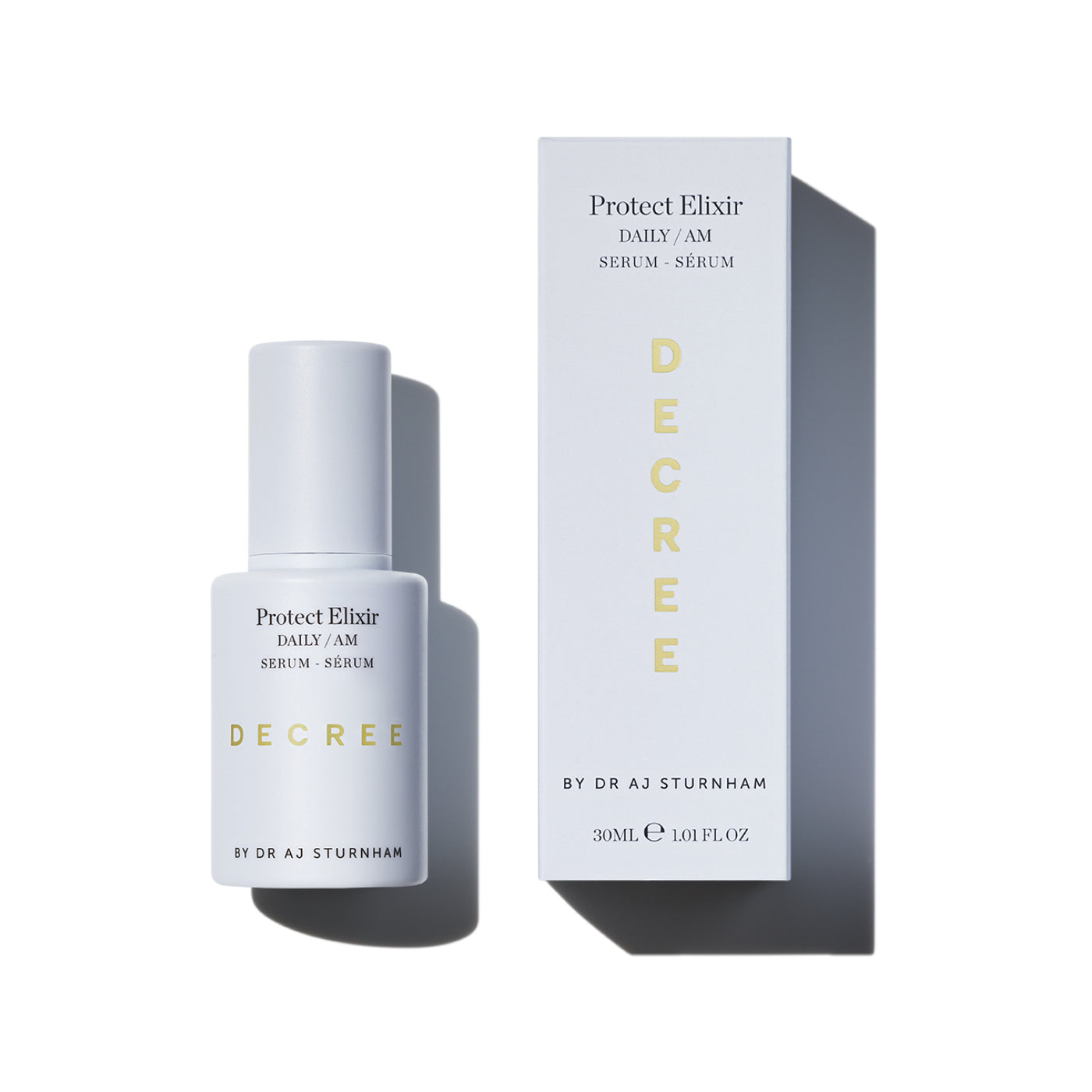 A white bottle of DECREE Protect Elixir Daily AM Serum stands next to its matching white box with gold lettering, set against a clean white background with soft shadows. Decree Protect Elixir antioxidant day serum with vitamin C, niacinamide, hyaluronic acid, and protective minerals.